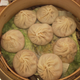 Eight unexpectedly huge soup dumplings on unexpected cabbage leaves. (Quartz/Siyi Chen)